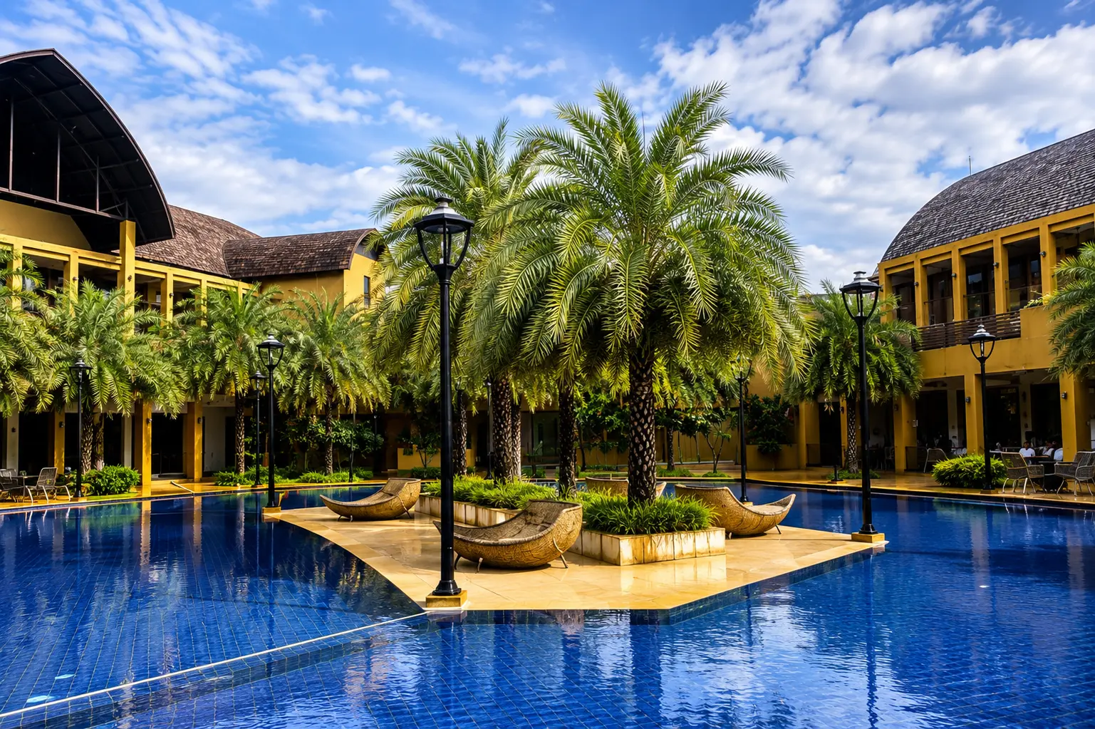 Club Laguna courtyard pool with palm island and lounges — actual image